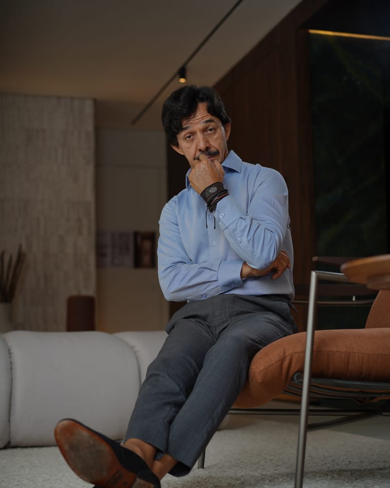 Gaspar Lopes sentado, pensativo, em seu ateliê