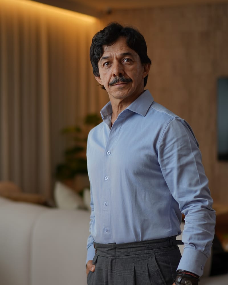 Gaspar Lopes em pé, de camisa e calça sob medida